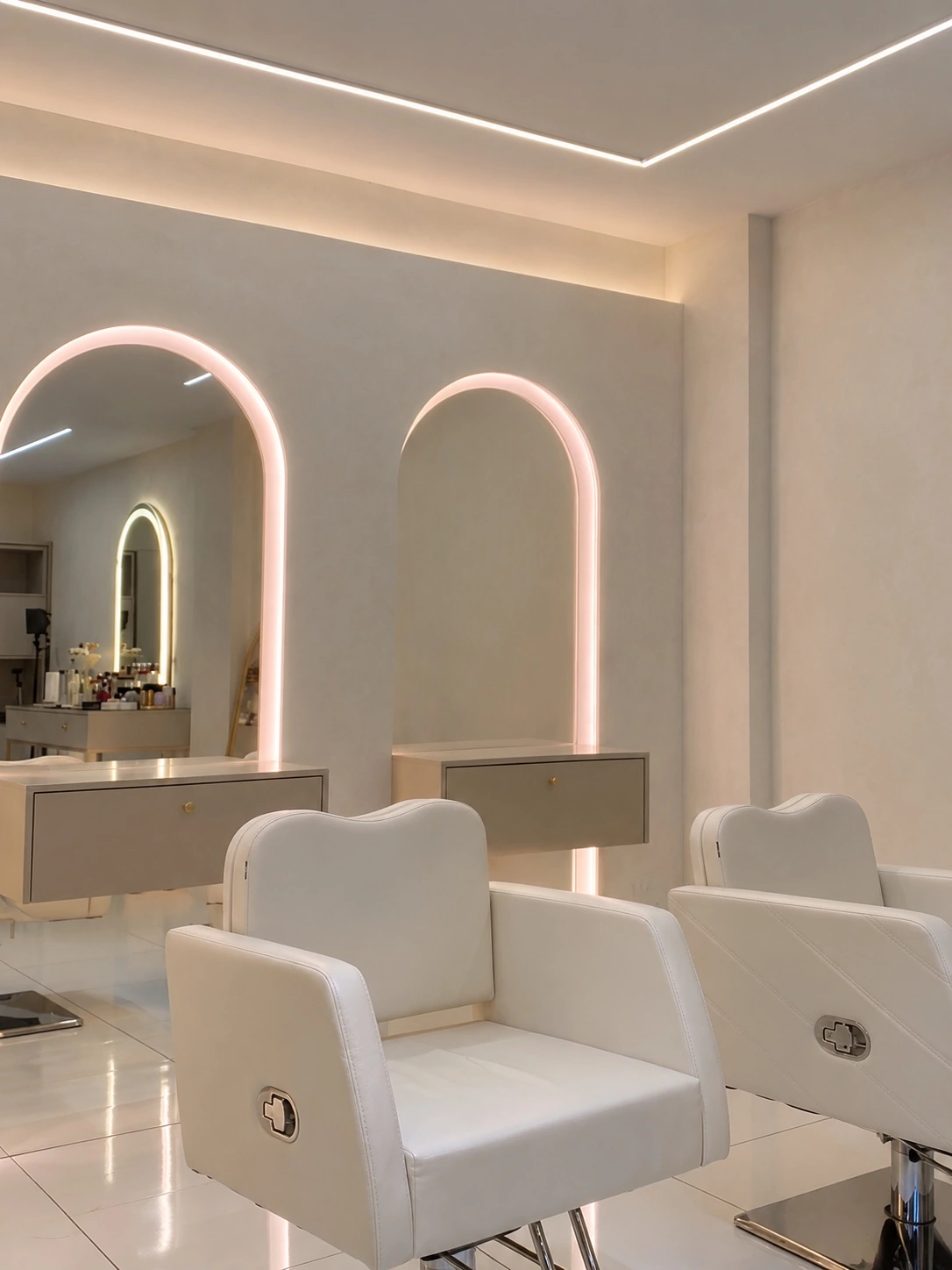 Bancadas com espelhos arqueados iluminados e poltronas do studio